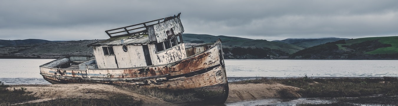 Old weathered boat stranded on land